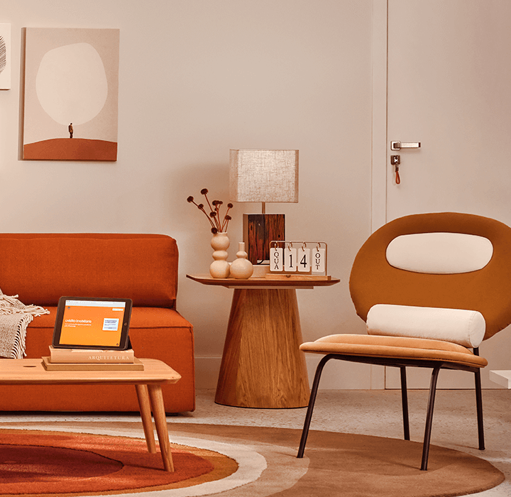Sala de estar com uma cadeira laranja, uma poltrona laranja e uma mesa com um abajur